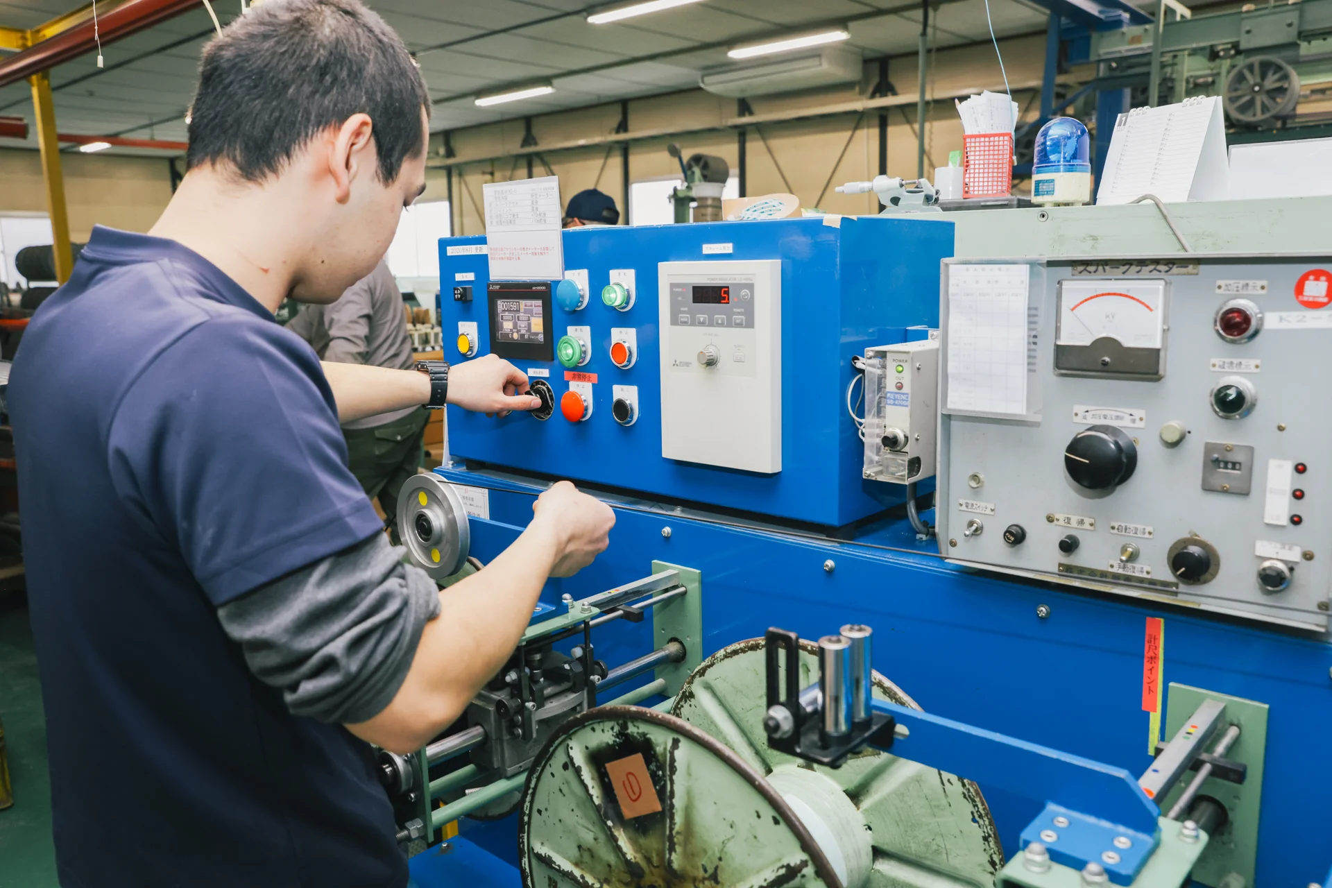 電線製造設備の設定を調整する社員